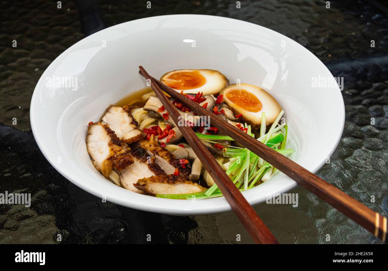 Sopa de fideos japoneses Ramen con huevos marinados, algas, chashu y caldo Foto de stock