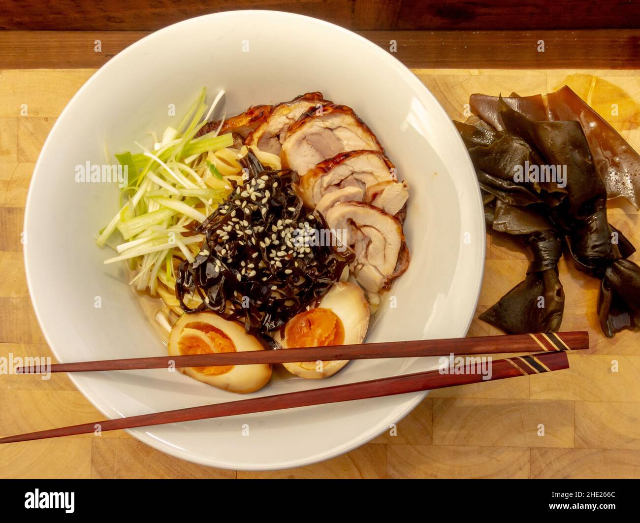 Sopa de fideos japoneses Ramen con huevos marinados, algas, chashu y caldo Foto de stock