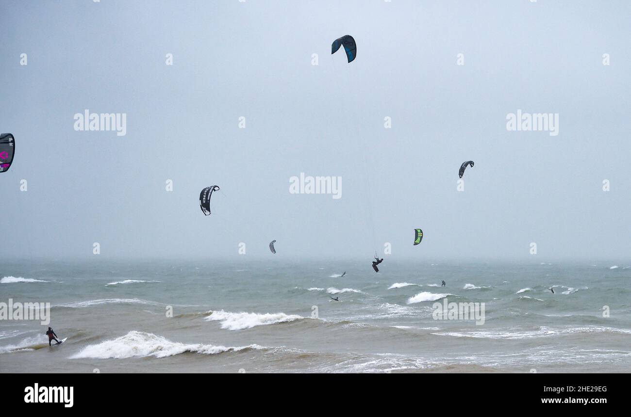 Worthing UK 8th de enero de 2022 - Los windsurfistas hacen el máximo de las condiciones en Lancing entre Brighton y Worthing como barridos de tiempo húmedo y ventoso a través de Gran Bretaña hoy : Crédito Simon Dack / Alamy Live News Foto de stock