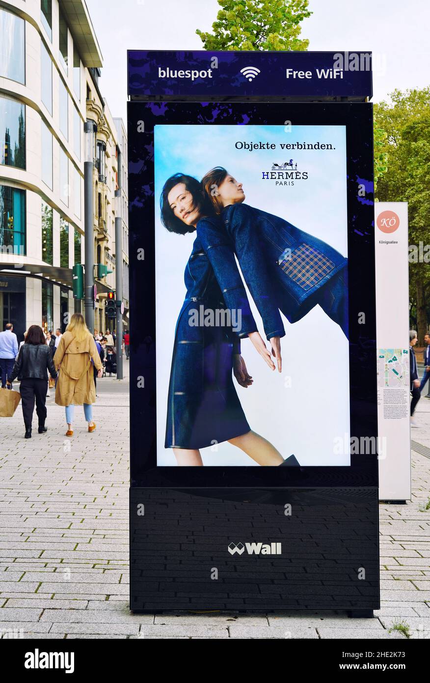 El bulevar comercial Königsallee en Düsseldorf/Alemania con la moderna pared de publicidad digital / bluespot WiFi gratuito. Foto de stock