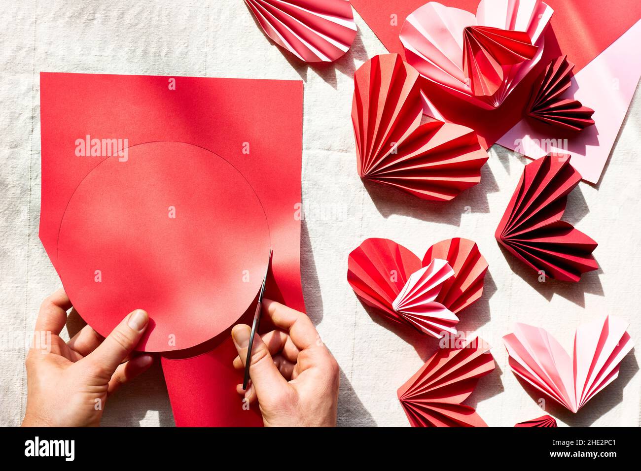 Generacion Empuje hacia abajo Por separado Las manos de la mujer hacen corazones de papel. Guirnalda de origami.  Símbolo de amor por el día de San Valentín, feliz cumpleaños, saludos, Día  de la Madre, Día de la Mujer.
