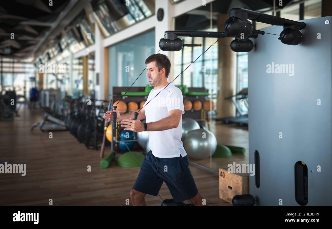 Hombre haciendo ejercicio en el gimnasio en una máquina de cubierta Pec  para el pecho y los músculos pectorales cable crossover entrenamiento  Fotografía de stock - Alamy