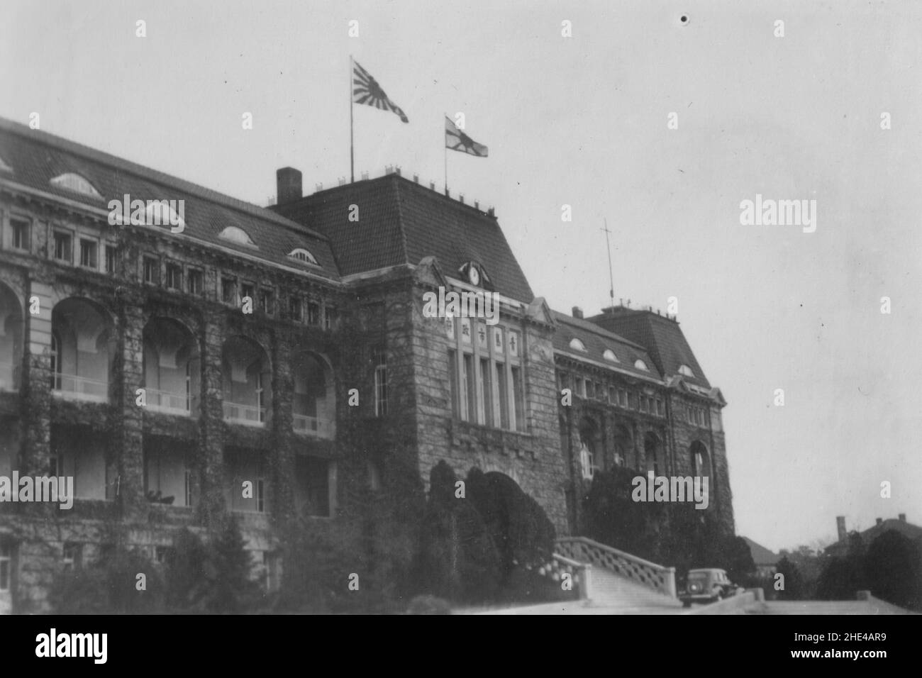 Segunda Guerra Sino-Japonesa, 1937-1945. El Ayuntamiento de Tsingtao (Qingdao) bajo la ocupación de la Armada Imperial Japonesa, la bandera de un almirante trasero y el cartel naval vuelan desde la azotea, alrededor de 1938. Foto de stock