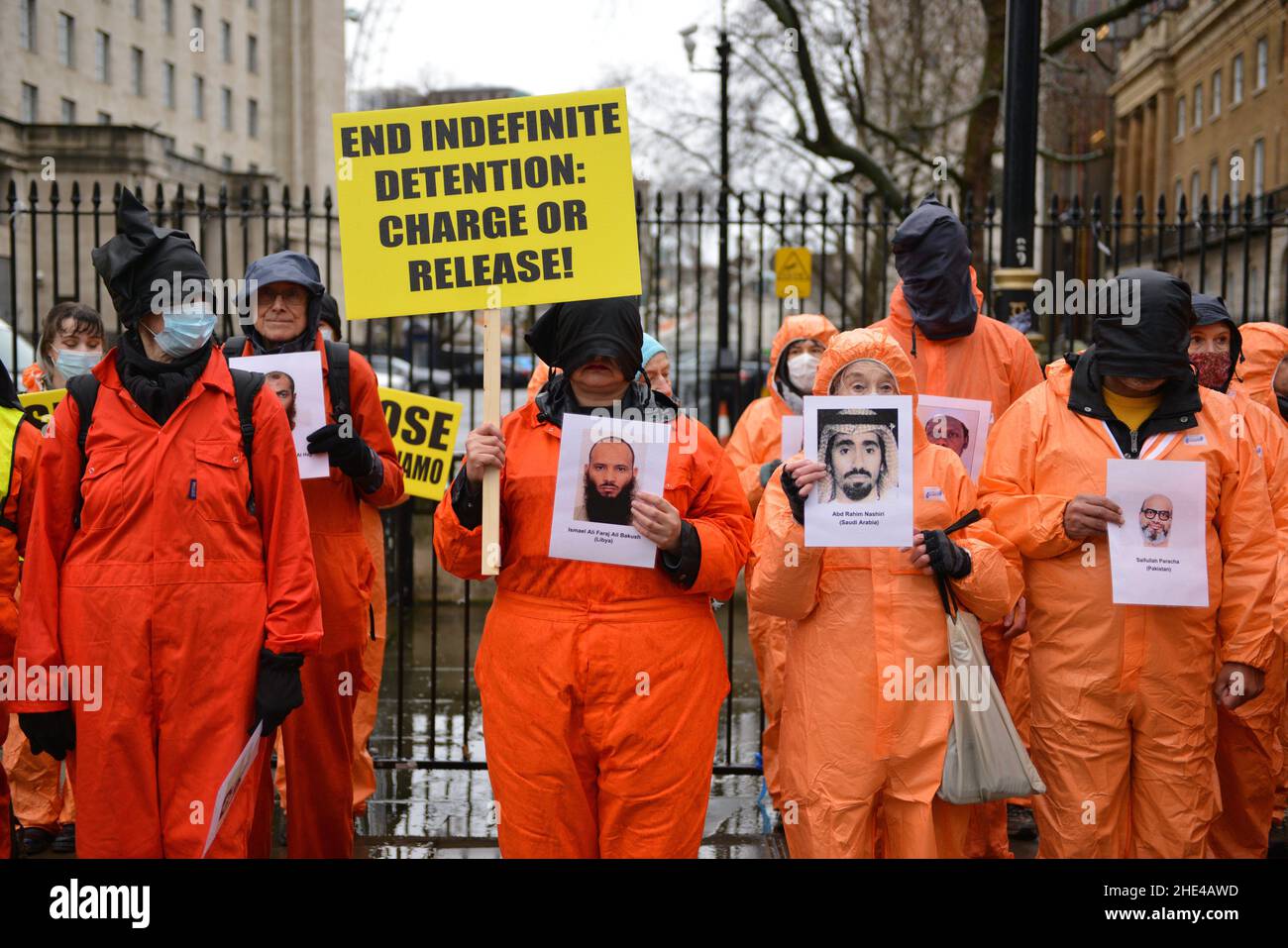 Londres, Reino Unido. 08th de Ene de 2022. Durante la manifestación, los manifestantes que llevaban capuchas negras retienen retratos de detenidos. Activistas vestidos de jumpsuits y campanas de color naranja, que representan a los 39 hombres que aún permanecen detenidos en el campo de detención de la Bahía de Guantánamo, marcharon desde la Plaza del Parlamento hasta la Plaza Trafalgar, que marcó 20 años del Campamento. Crédito: SOPA Images Limited/Alamy Live News Foto de stock