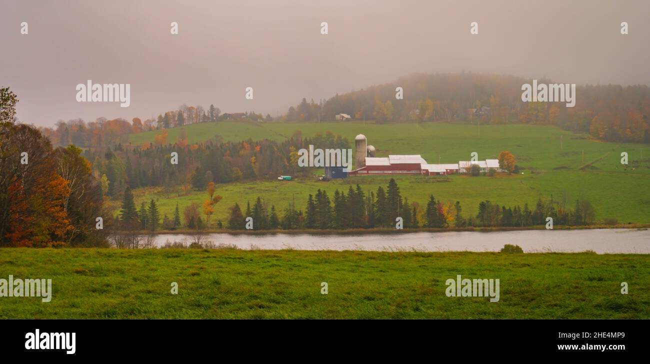 granja a lo largo del río en el día lluvioso en otoño Foto de stock