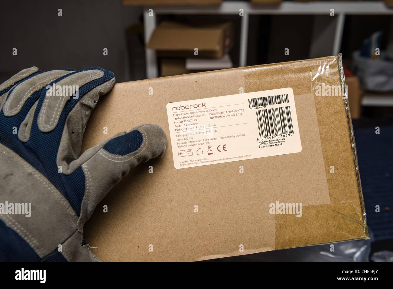 Frankfurt, Alemania - 10 de diciembre de 2021: Mano macho en la protección  de guantes de sujeción en el almacén de Amazon Cardboard caja con Roborock  S6 robot aspirador Fotografía de stock - Alamy