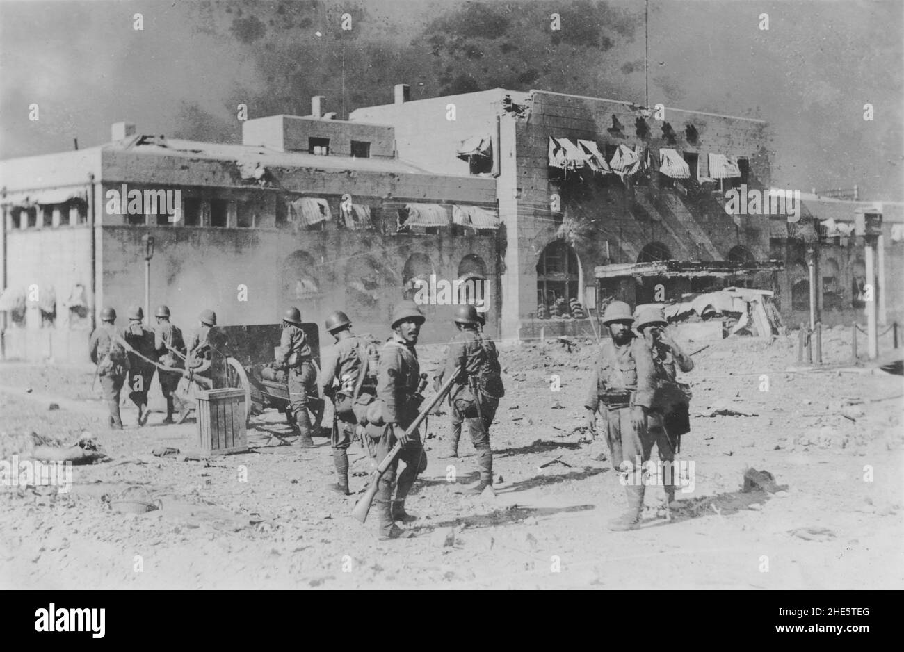 Segunda Guerra Sino-Japonesa, 1937-1945. Las tropas de la Fuerza de Desembarco Naval Japonesa remolinan una pieza de artillería frente a la estación norte de Shanghai, devastada por la guerra, durante la batalla de Shanghai, agosto-noviembre de 1937. Foto de stock