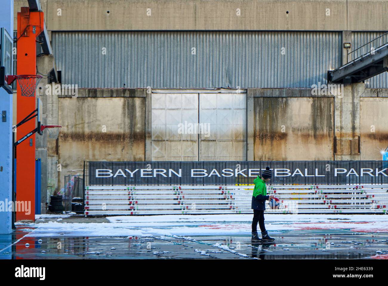 Un niño juega con su pelota en una cancha de baloncesto en Munich durante la Pandemia Corona - descongeló en el Centro Cultural de Sugar Mountain. Foto de stock