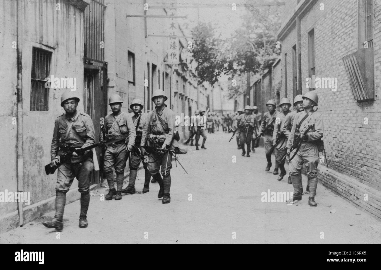 Segunda Guerra Sino-Japonesa, 1937-1945. Las tropas de la Fuerza Naval de Desembarque Especial Japonesa escanearon un callejón en busca de tropas enemigas del Ejército Revolucionario Nacional Chino durante la Batalla de Shanghai, de agosto a noviembre de 1937. Foto de stock