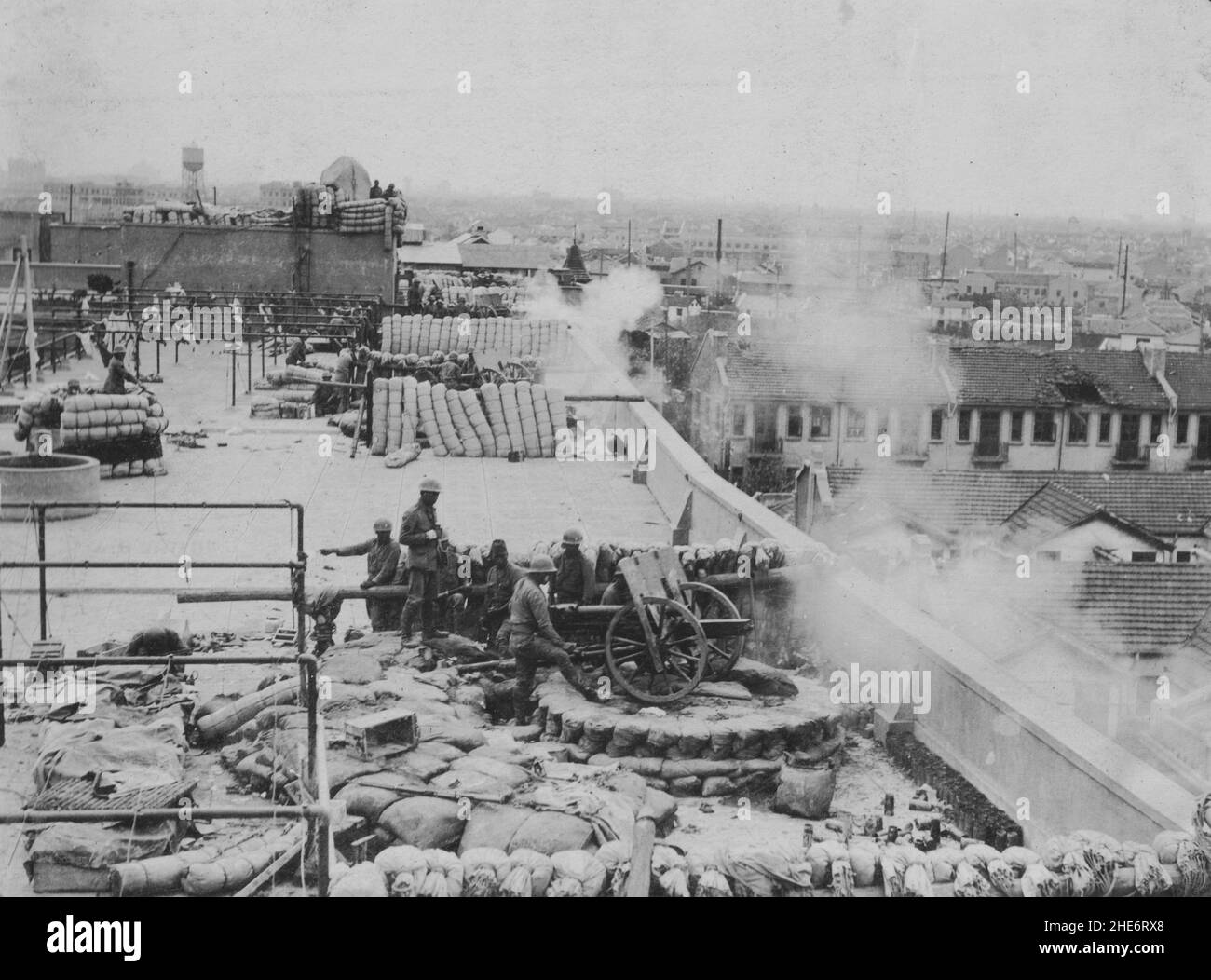 Segunda Guerra Sino-Japonesa, 1937-1945. Las tropas de la Fuerza Naval de Desembarque Especial Japonesa disparan un número de 75mm cañones de montaña desde una posición fortificada en la azotea durante la Batalla de Shanghai, de agosto a noviembre de 1937. Foto de stock