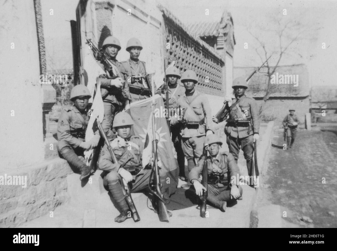 Segunda Guerra Sino-Japonesa, 1937-1945. Las tropas de la Fuerza de Desembarco Naval Japonesa de la Base Naval Ryojun (Port Arthur) desplegadas en la provincia de Shandong exhiben orgullosamente una bandera capturada de las fuerzas chinas alrededor de Weihaiwei, alrededor de 1939. La Armada Imperial Japonesa invadió Shandong a principios de 1938, capturando ciudades costeras vitales y ocupándolas hasta la rendición del Imperio Japonés en 1945. Foto de stock