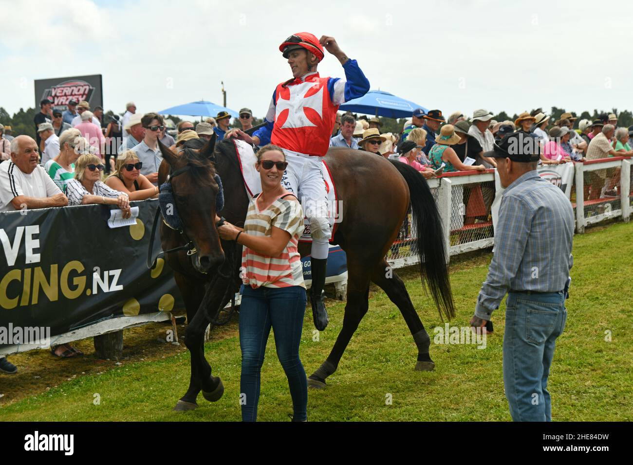 KUMARA, NUEVA ZELANDA, 8 DE ENERO de 2022; jinete Jason Laking se desmonta en el círculo de ganadores después de ganar la carrera de Nuggets de Oro en el Kumara Race Track en Camino rocoso, 8 de enero de 2022 . Foto de stock