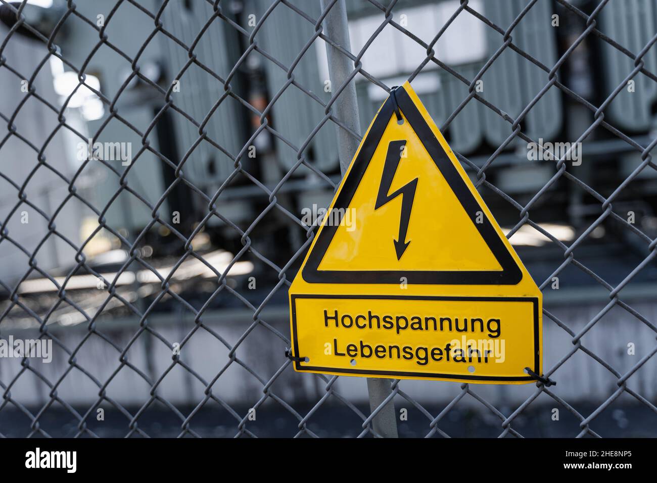Firmar Achtung Hochspannung Lebensgefahr en la Fence de una Subestación Eléctrica Foto de stock