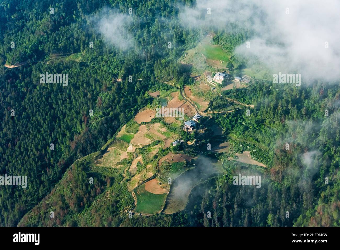 Vista aérea de la aldea y las tierras de labranza en la montaña, Bután Foto de stock