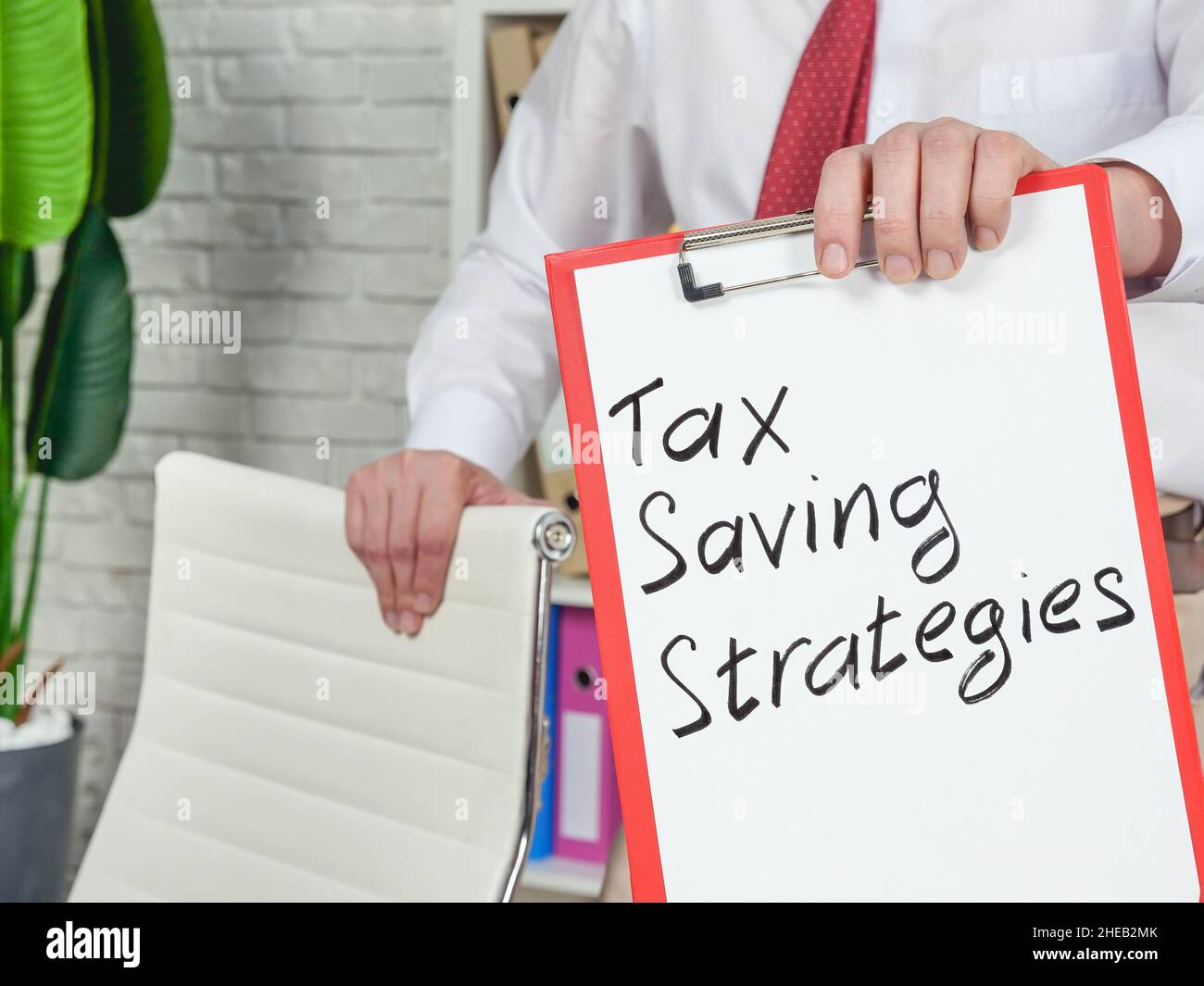 Un asesor financiero muestra estrategias de ahorro de impuestos. Foto de stock