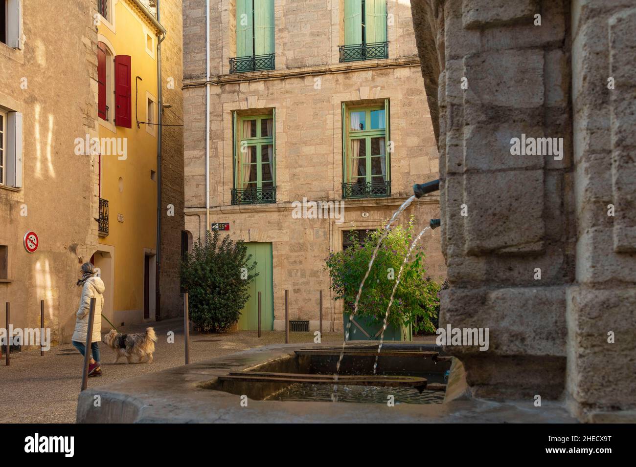 Francia, Hérault, Pezenas, pasando por una plaza con una fuente en el centro histórico de un pueblo del sur Foto de stock