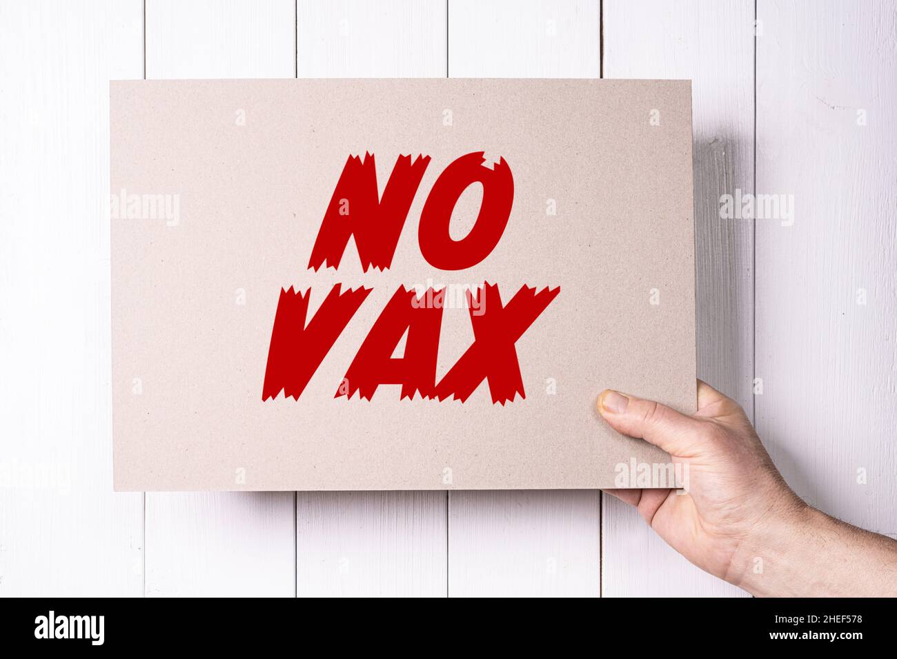 Un signo con las palabras No VAX sostenidas en la mano Foto de stock