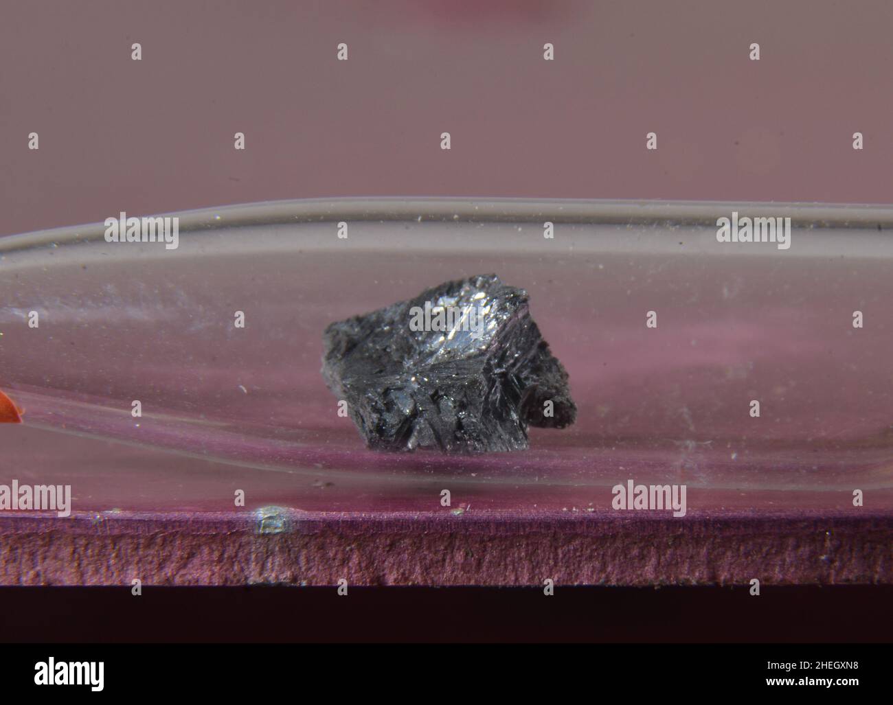 Microfotografía de una muestra del elemento periódico No. 33: Arsénico. El metal tóxico se almacena en una ampolla de vidrio Foto de stock