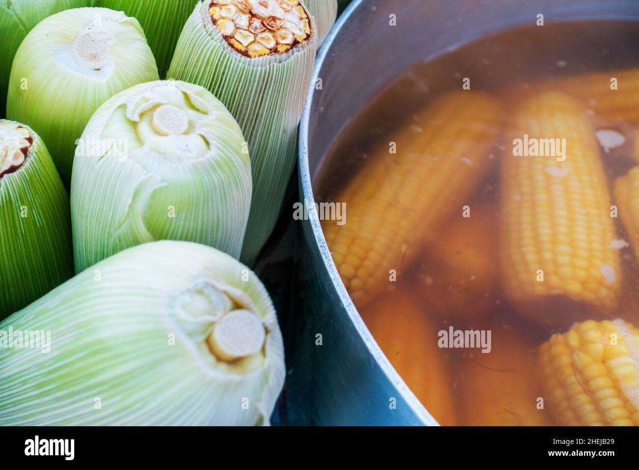 Maíz descascarillado y maíz hirviendo en un mercado en América Latina Foto de stock