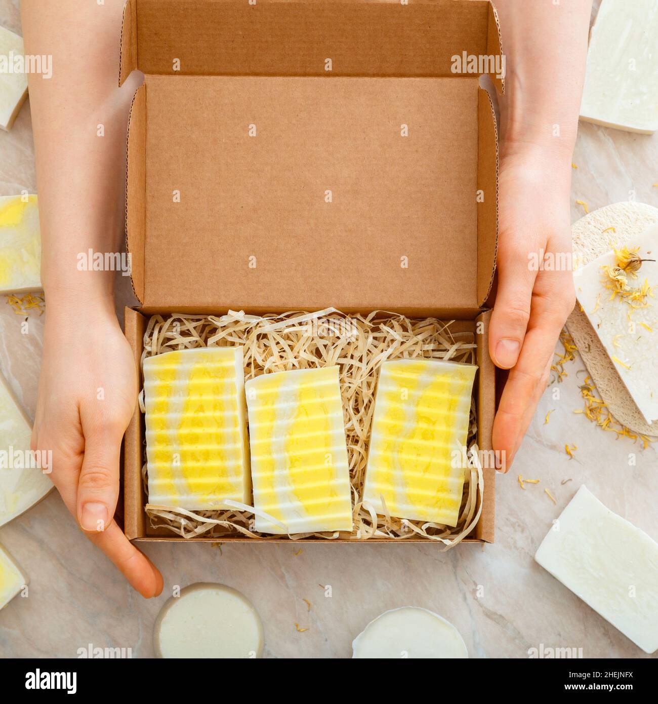 Caja de regalo con juego de jabón natural en manos femeninas. Kit de jabones  DIY. Muchos jabones de bar caseros. Artículos de higiene Artículos de aseo  Plana LONG Square closeup Fotografía de