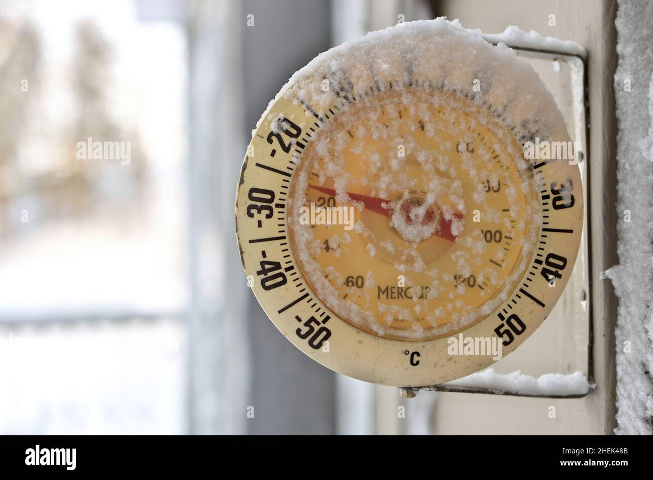 Termómetro para exteriores con nevadas heladas en un día de invierno frío y frío Foto de stock