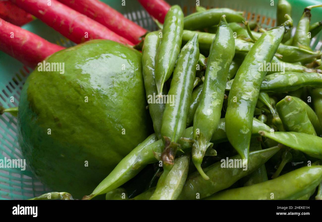 verduras de invierno variadas. guisantes verdes, papaya, zanahorias recién cosechadas de la granja orgánica y mantenidas juntas. tiro de cerca. Foto de stock