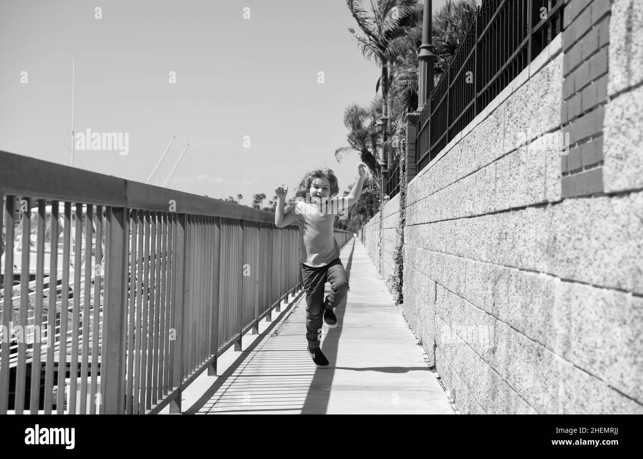 No se rompa. Niños con mucha energía corren por el paseo marítimo. Feliz niño disfrutar de tiempo libre. Divertirse. Vacaciones de verano Foto de stock