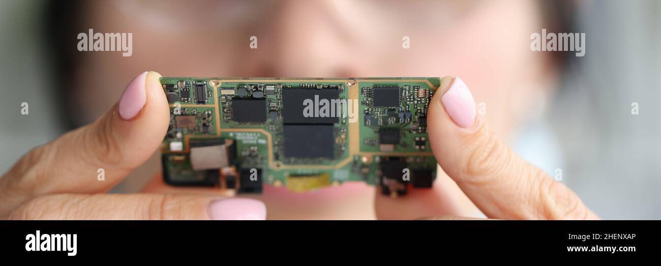 A través de la lente de aumento, el ingeniero mira el chip de la computadora Foto de stock