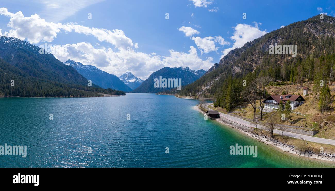 idílica casa de vacaciones junto a la carretera en el lago plansee en primavera con las montañas austriacas Foto de stock