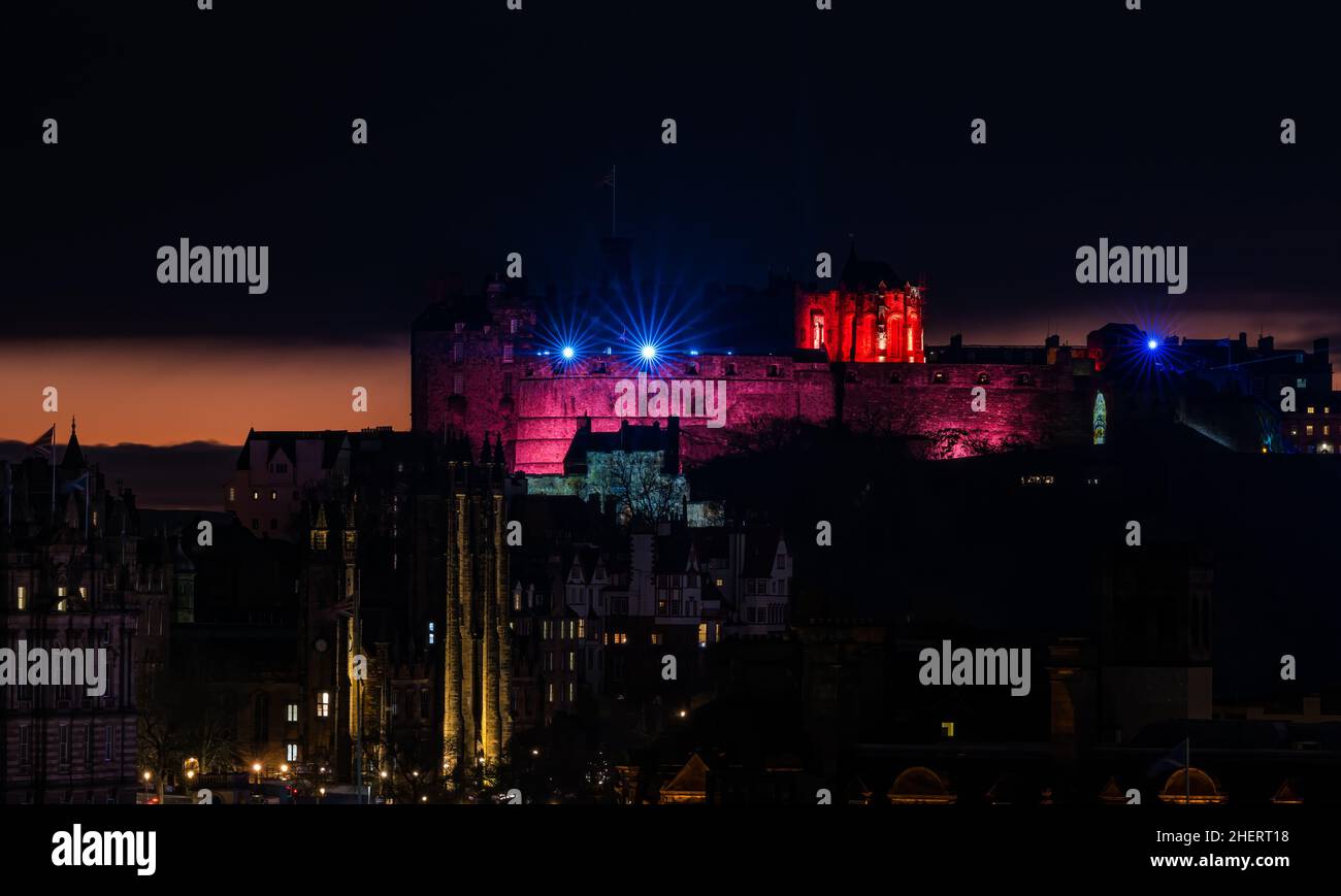 Proyecciones de luz del castillo de Edimburgo y la torre del reloj Balmoral encendida por la noche al atardecer, Edimburgo, Escocia, Reino Unido Foto de stock