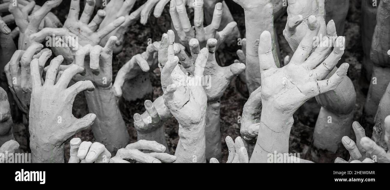 WAT RONG KHUN - TEMPLO BLANCO, CHIANG RAI TAILANDIA - ALREDEDOR DE MAYO DE 2018. La escultura de cientos de manos que superan a las que simbolizan el deseo sin restricciones. Foto de stock