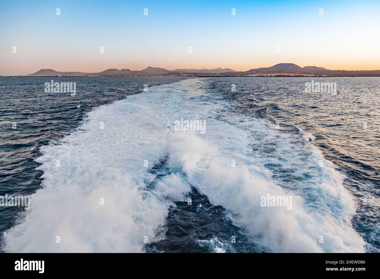 espume de ferry con el horizonte de lanzarote en el fondo al atardecer Foto de stock