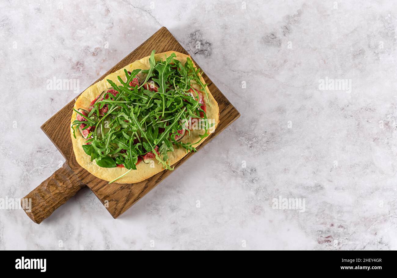 Pinsa Romana vegetariana o pizza casera con queso, higos, rúcula y miel