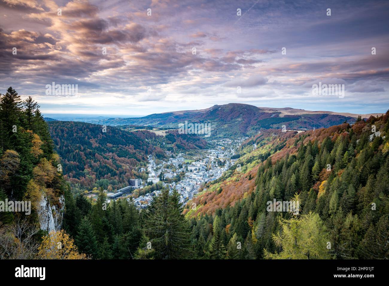 Ciudad de Mont Dore con bosque y montañas detrás Foto de stock