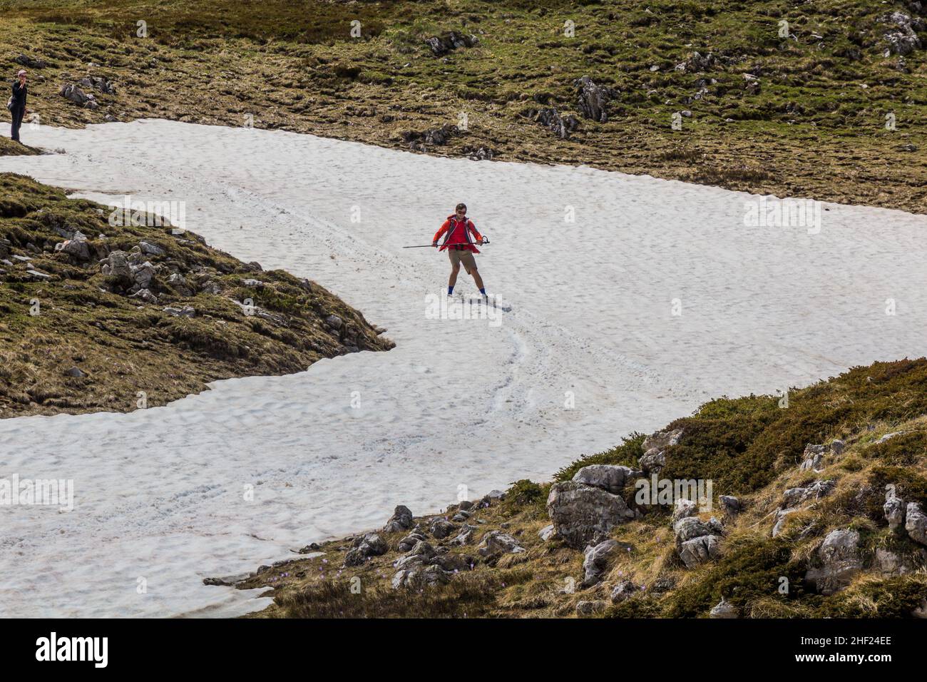 DURMITOR, MONTENEGRO - 6 DE JUNIO de 2019: Excursionista disfrutando de la nieve en el parque nacional Durmitor, Montenegro. Foto de stock