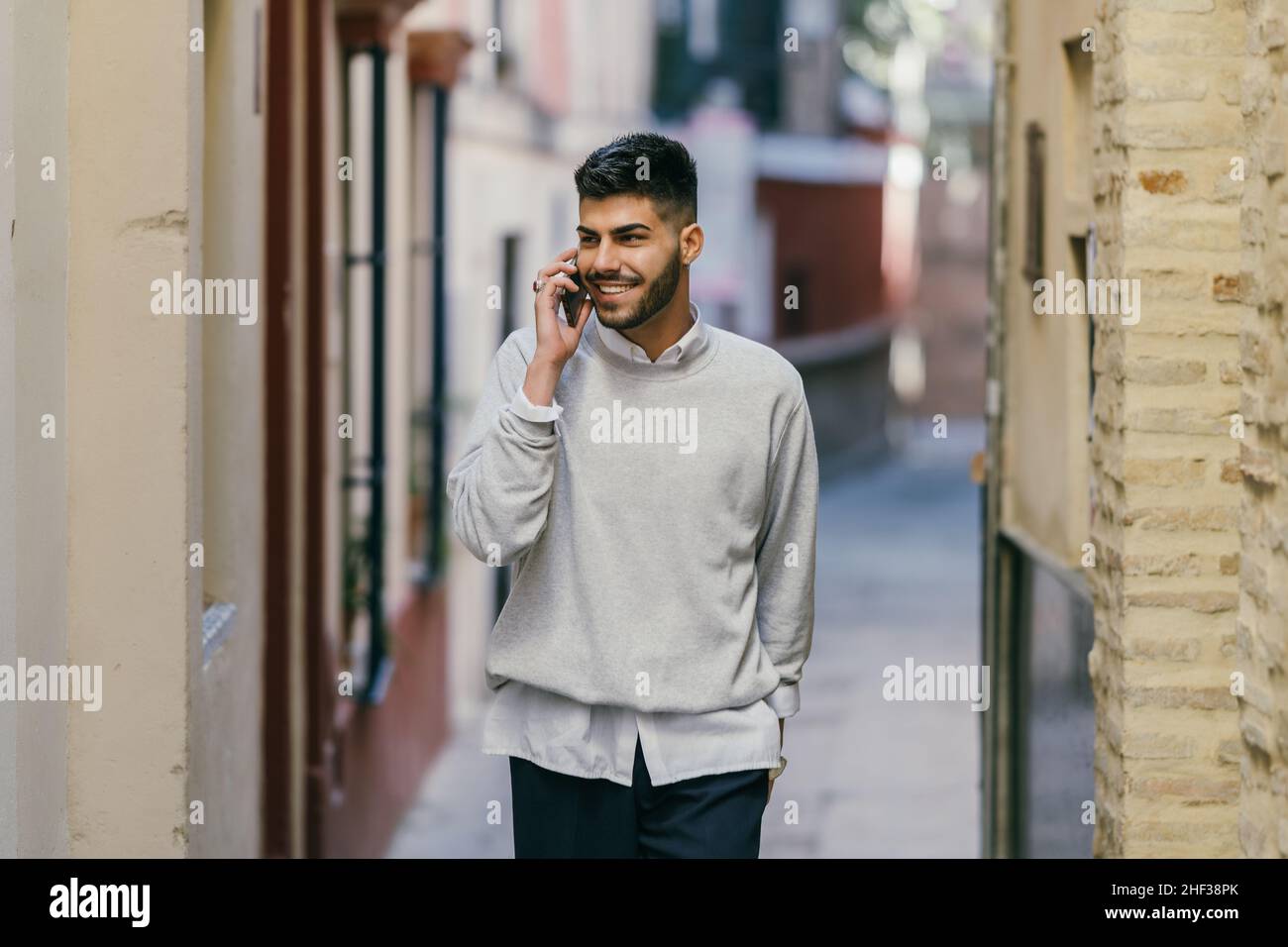Hombre joven caucásico con ropa moderna hablando con el móvil al aire libre  Fotografía de stock - Alamy