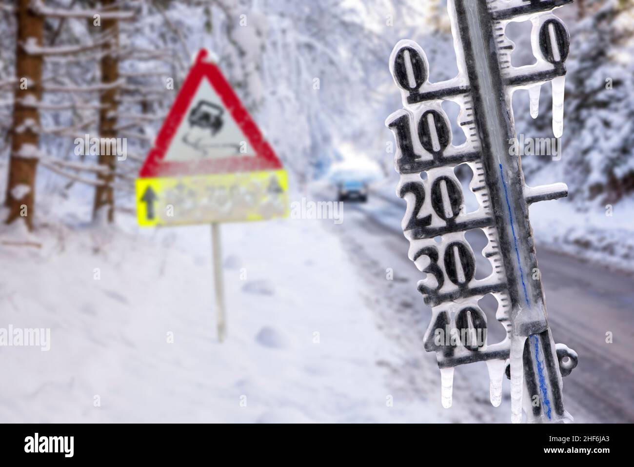 El termómetro muestra la temperatura fría y los icículos en invierno con el camino resbaladizo Foto de stock