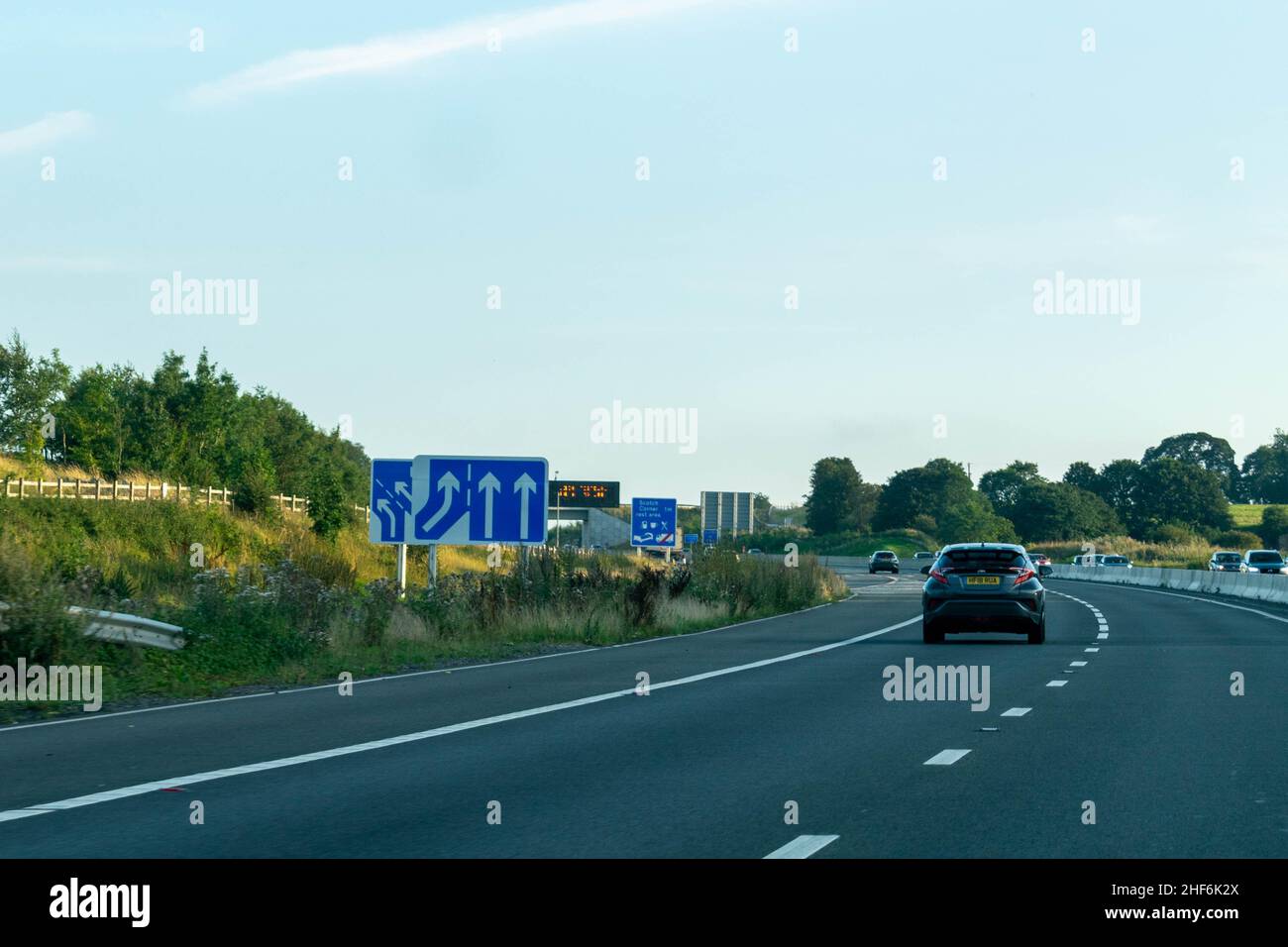 Leeds, Reino Unido - 23rd de agosto de 2019: Los coches conducen por una autopista británica con señales azules que aconsejan a los conductores de un carril de filtro, carriles de conmutación, zona de descanso Foto de stock