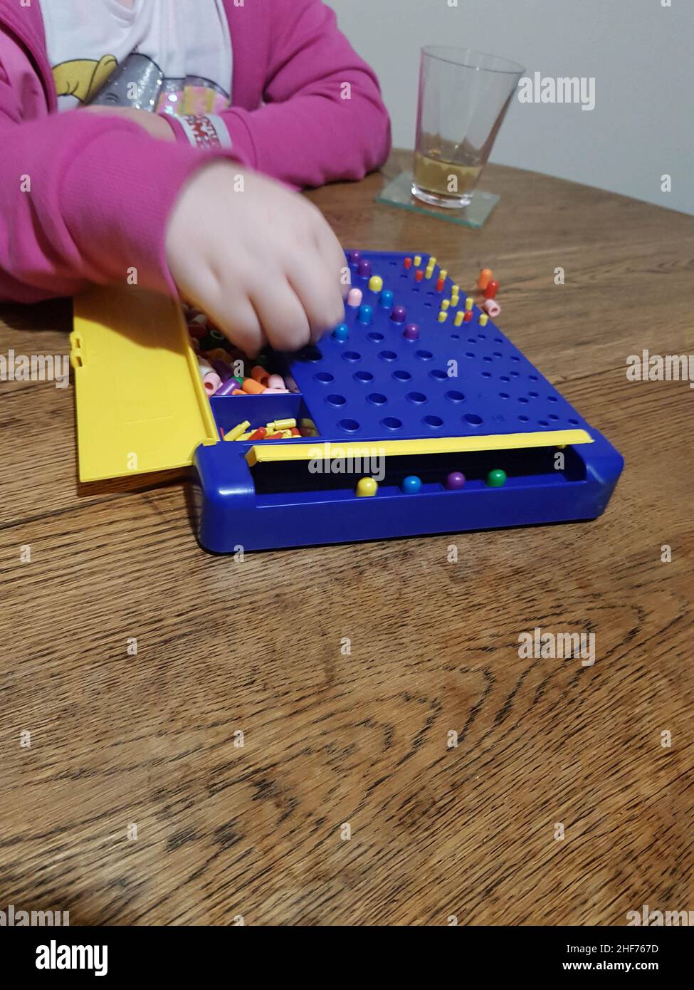 Niño jugando un juego de mesa de mastermind, el concepto es romper el  código de los oponentes de 4 colores. Tiempo de relajación en familia,  juego de mesa en una mesa de