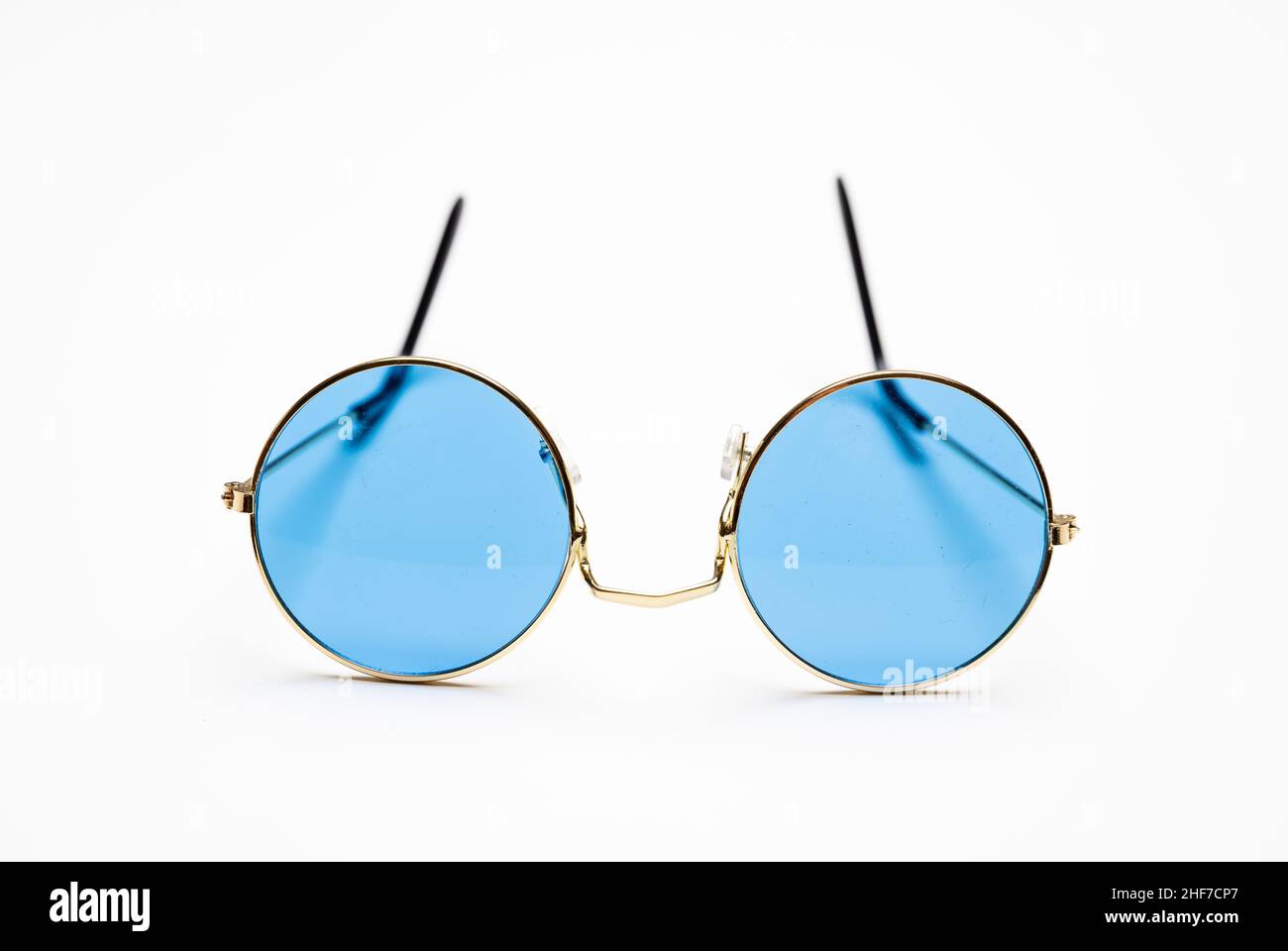 Gafas de sol con lentes de color azul y marco metálico redondo dorado aislado sobre fondo blanco, recortado, elemento de diseño Foto de stock