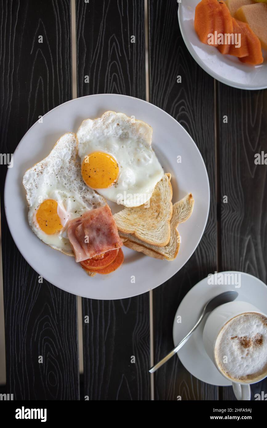Delicioso desayuno con huevos fritos y una taza de café en mesa negra  Fotografía de stock - Alamy