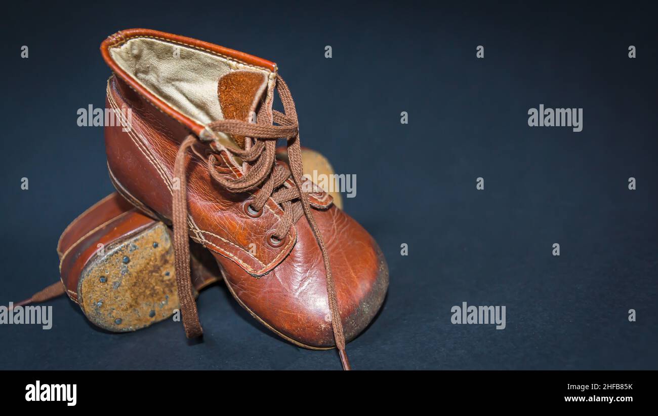 Ein paar braune Kinderlederschuhe aus den 50er Jahren vor neutralem dunkelblauen Hintergrund Foto de stock
