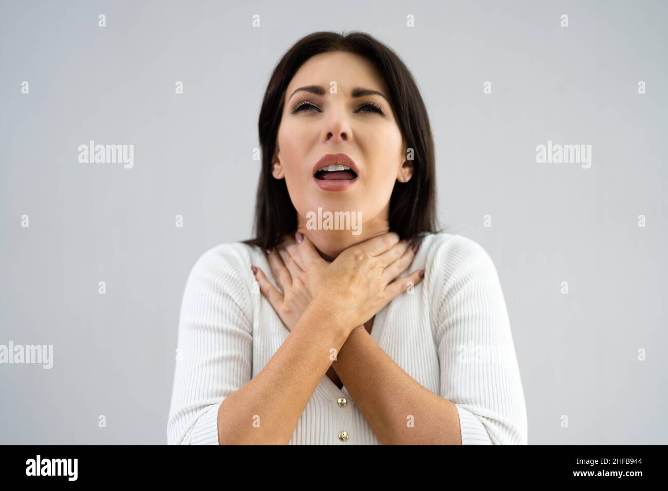 Trague el dolor y la inflamación de la garganta. Tocar el cuello Foto de stock