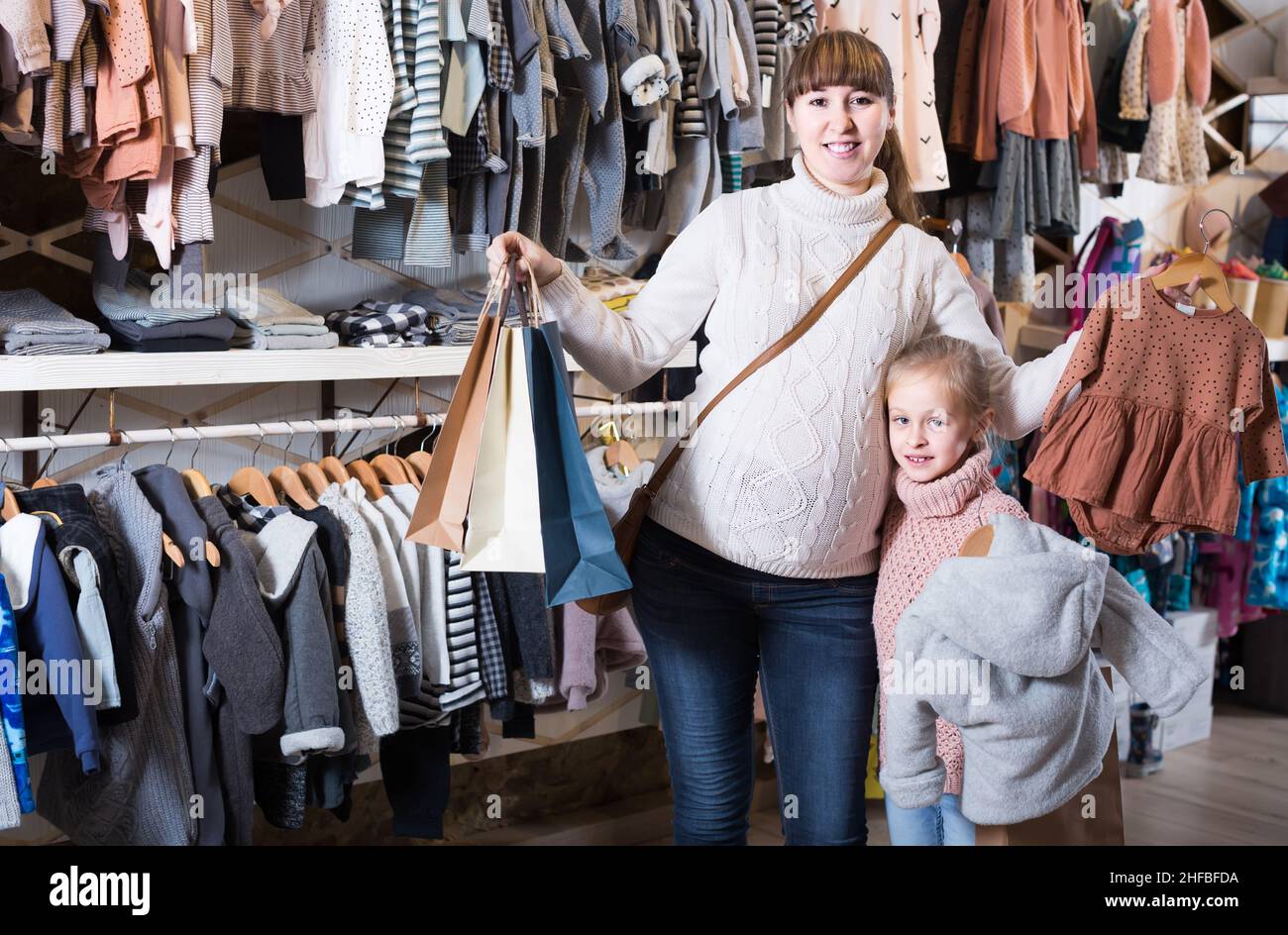 congestión revelación hilo Madre e hija embarazadas elegir suit para bebé en la tienda de ropa para  niños Fotografía de stock - Alamy
