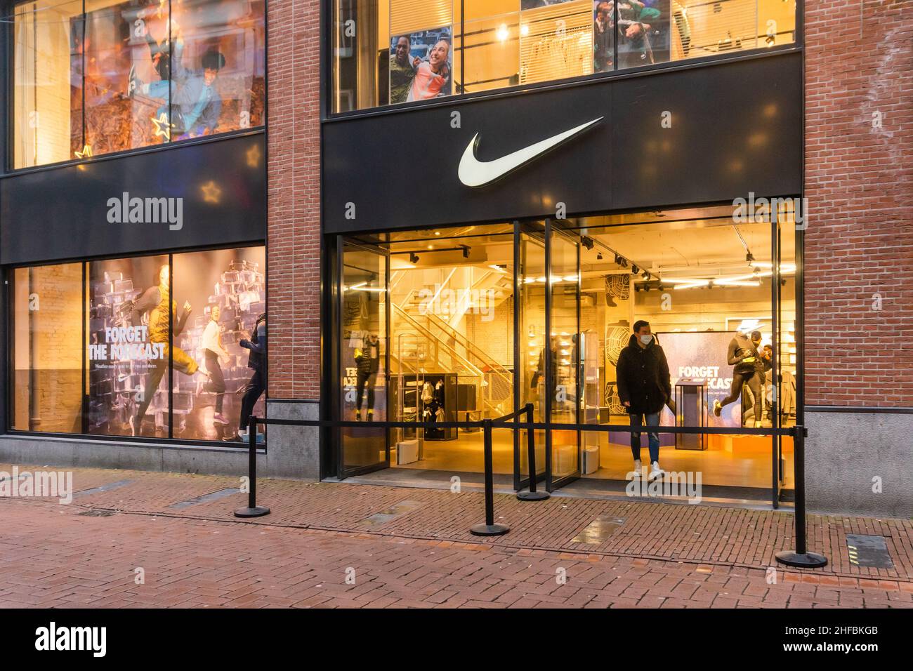 Ámsterdam, Países Bajos. 15 de enero de 2022. Las puertas están abiertas y  los soportes de cinta de barrera se colocan en la tienda Nike Sportswear en  Kalverstraat, donde un cliente temprano