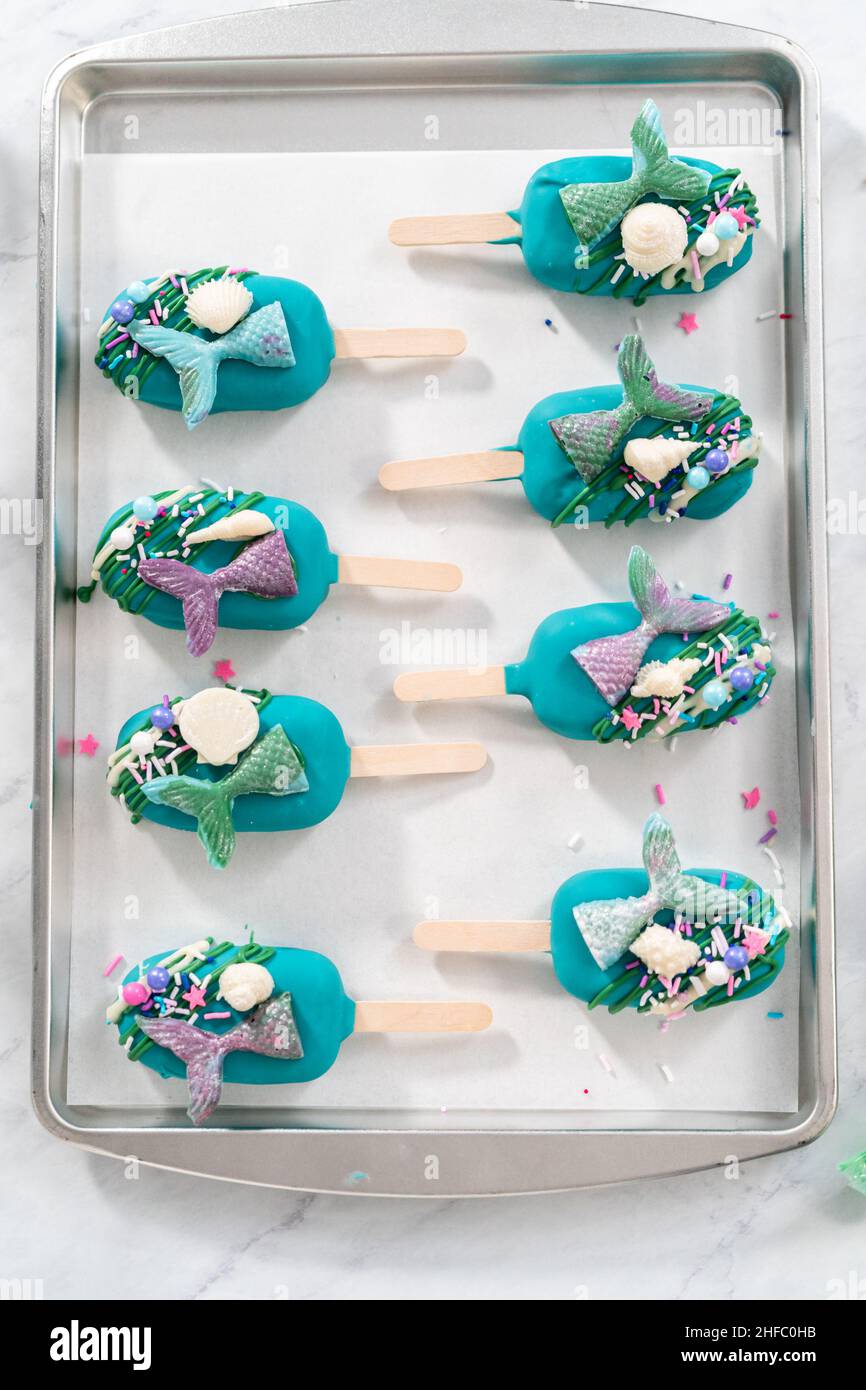 Las cakesicles de la sirena con chocolate regado, colas de la sirena de chocolate, conchas