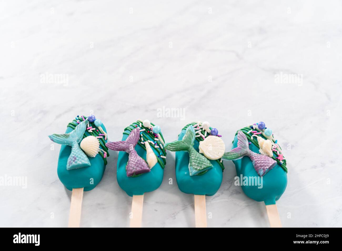 Las cakesicles de la sirena con chocolate regado, colas de la sirena de chocolate, conchas