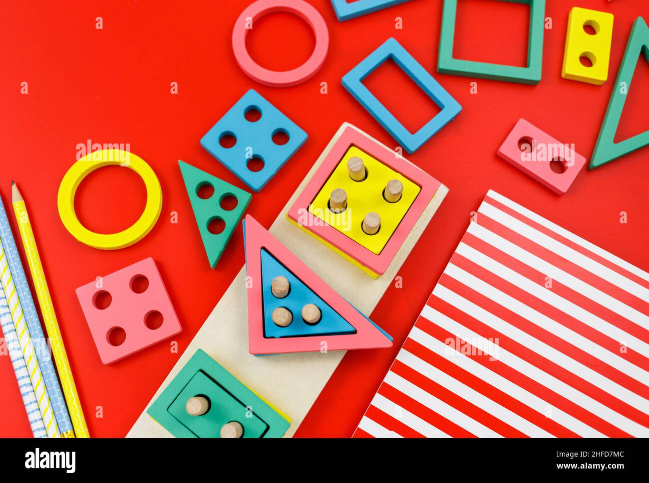 Bloques de madera multicolor sobre fondo rojo. Juguetes de puzzle de moda. Formas geométricas: Cuadrado, círculo, triángulo, rectángulo. Juguetes educativos Foto de stock