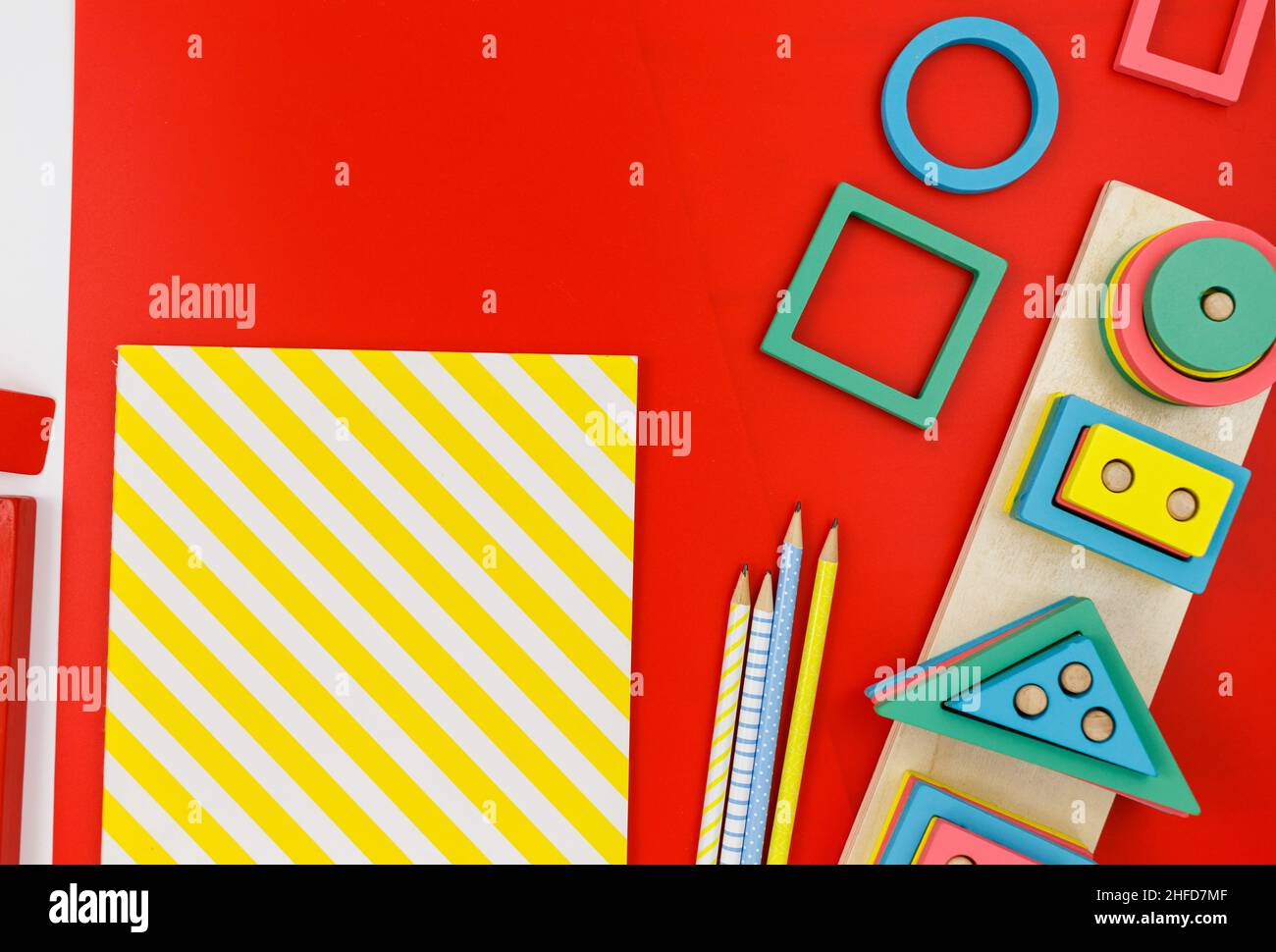 Bloques de madera multicolor sobre fondo rojo. Juguetes de puzzle de moda. Formas geométricas: Cuadrado, círculo, triángulo, rectángulo. Juguetes educativos Foto de stock