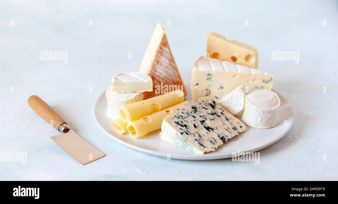 plato de queso con diferentes tipos de queso francés sobre fondo blanco Foto de stock